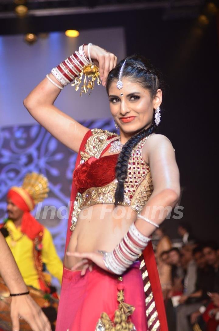 A model dances to the wedding theme at the IIJW 2014 - Day 2
