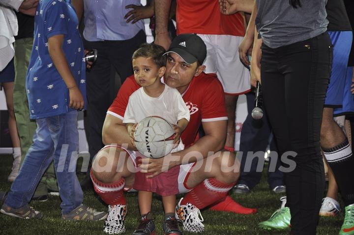 Aamir khan holds a kid at Charity Football Match