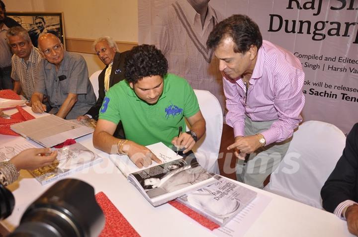 Sachin Tendulkar autographs a book at Durgapur Tribute Book Launch