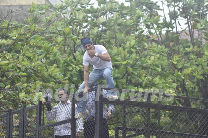 Shah Rukh Khan climbs up the fence to blow a flying kiss to his fans