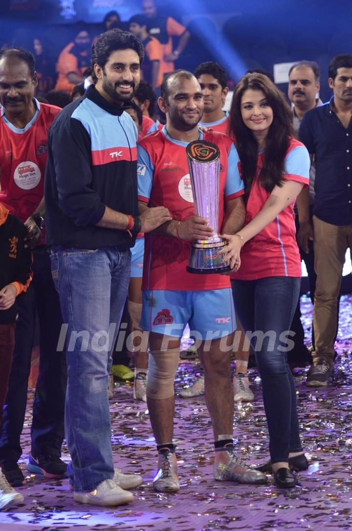 Abhishek and Aishwarya hand over a trophy to a team member of Jaipur Pink Panthers