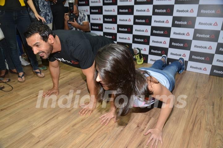 John Abraham and Nargis Fakhri do a push up exercise at the Press Meet of Reebok