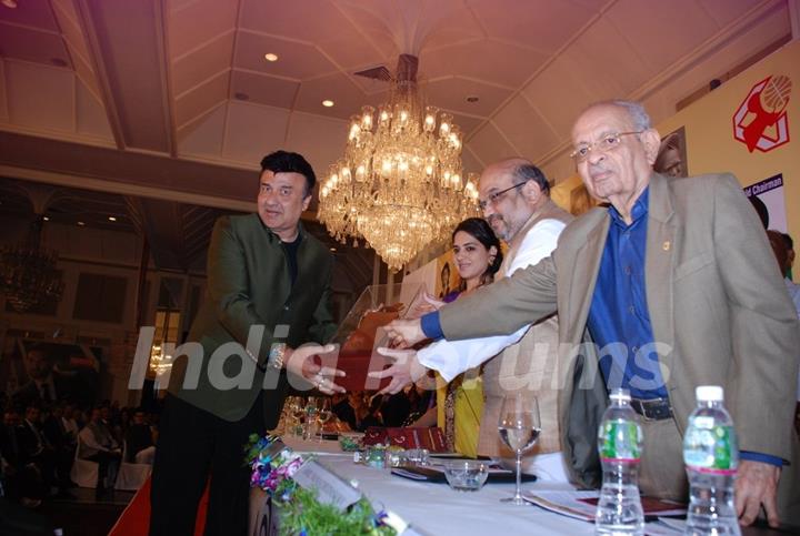 Anu Malik receiving a trophy at Giant Awards in Trident