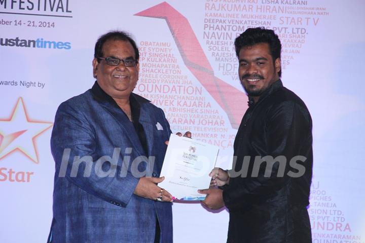 Satish Kaushik presents an award to a winner at the Closing Ceremony of 16th MAMI Film Festival