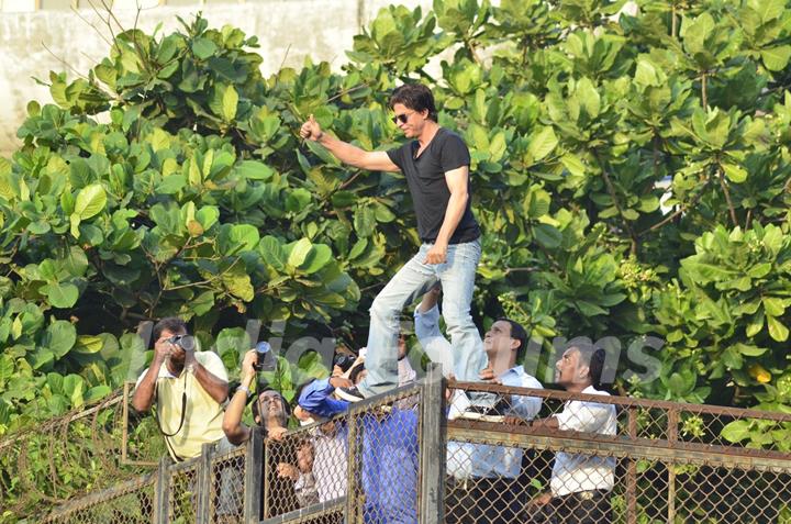 Shahrukh Khan climbs over the railing to greet his fans