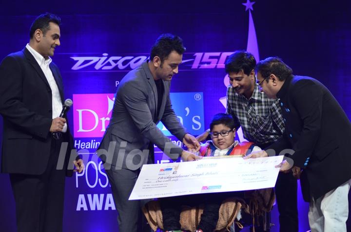 MS Dhoni presents an award to a special child at Positive Health Awards