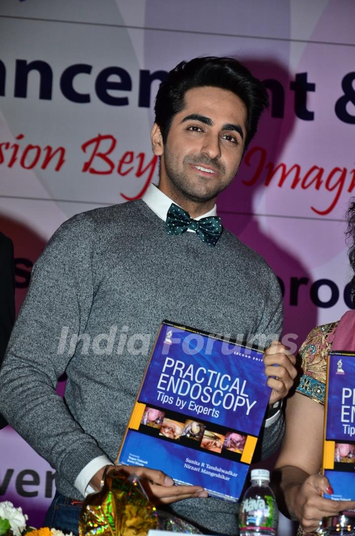 Ayushmann Khurrana poses with a book at Fertility Conference