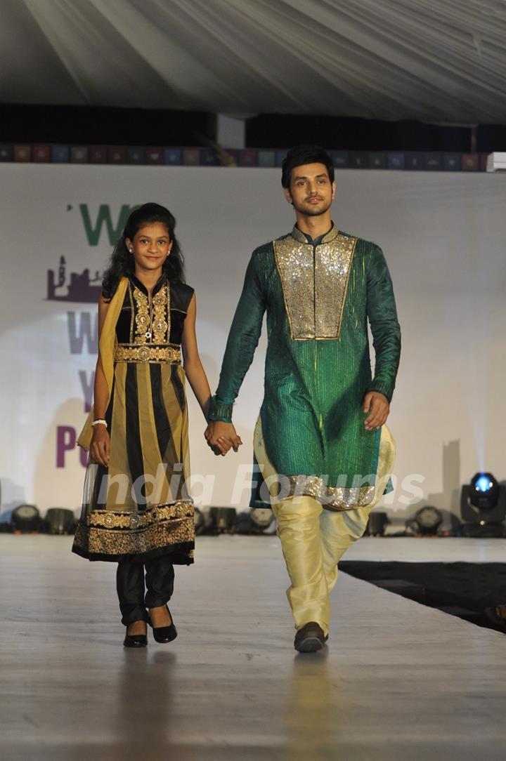 Shakti Arora walks the ramp with a small girl at Wellingkar's 26/11 Tribute