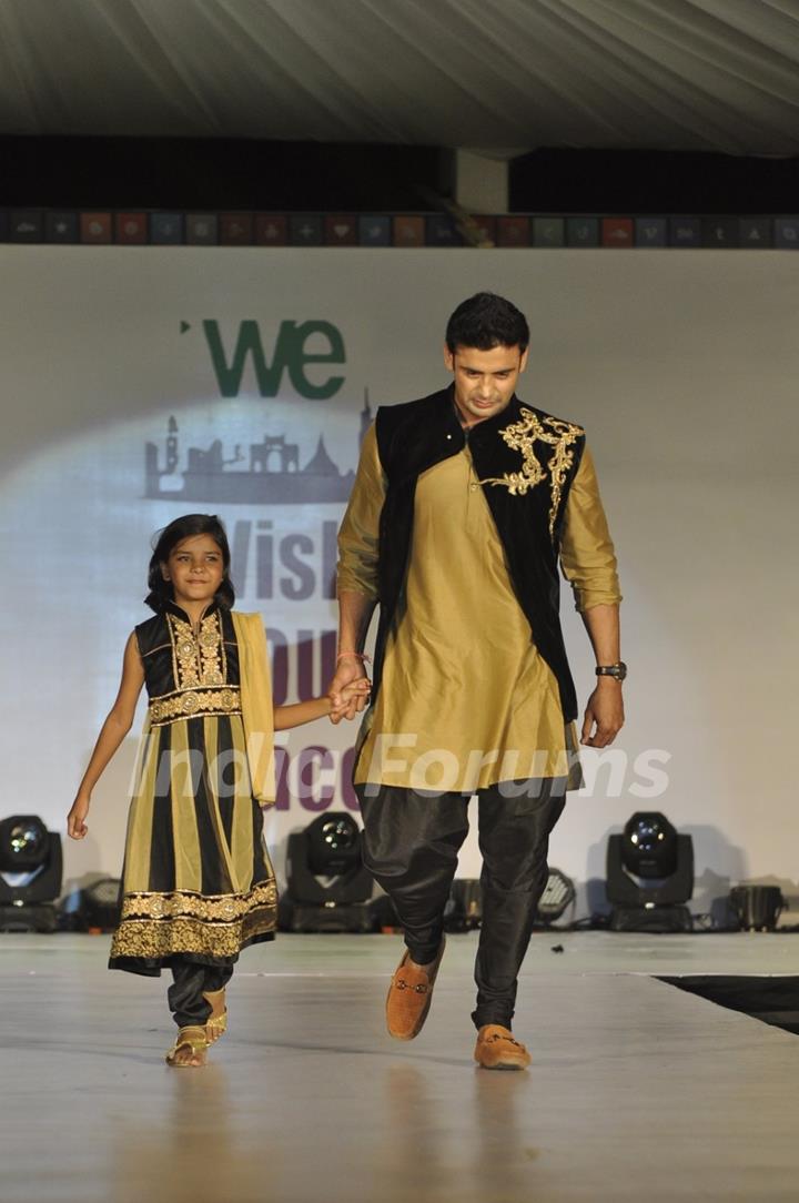 Sangram Singh walks the ramp with a small girl at Wellingkar's 26/11 Tribute