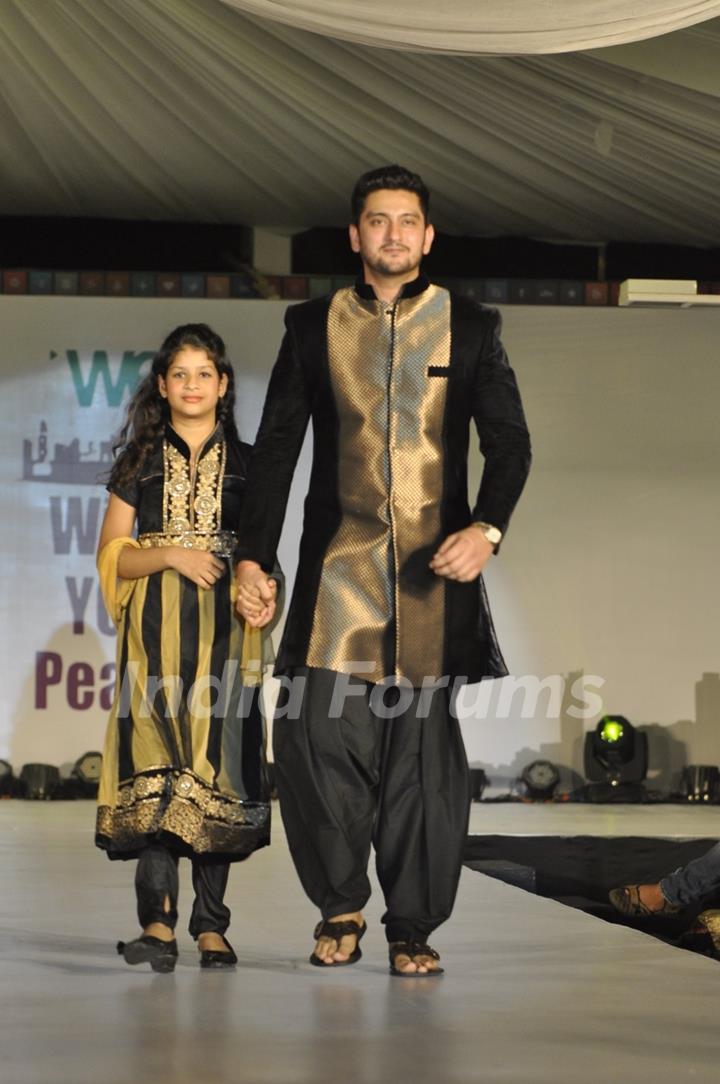 Shaad Randhawa walks the ramp with a small girl at Wellingkar's 26/11 Tribute