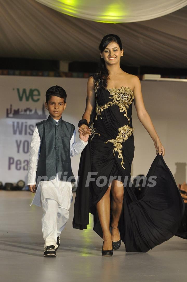 Shakti Mohan walks the ramp with a small boy at Wellingkar's 26/11 Tribute