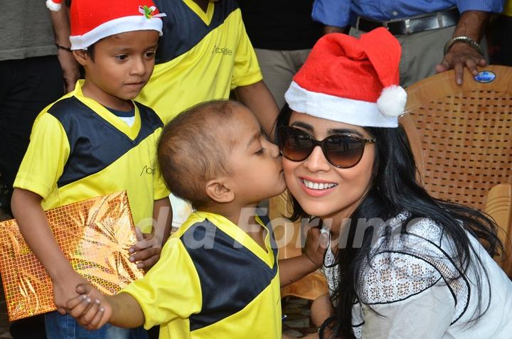 A small kid gives Shriya Saran a kiss at the Christmas Celebration