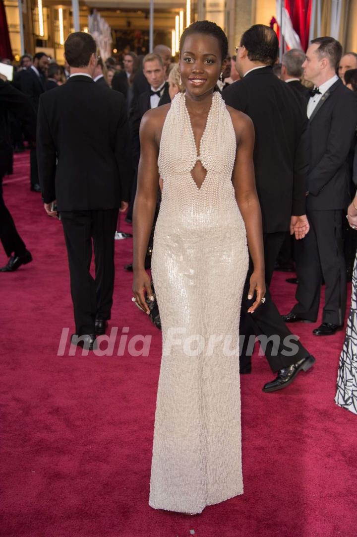 Lupita Nyong'o poses for the media at the Oscars Red Carpet 2015