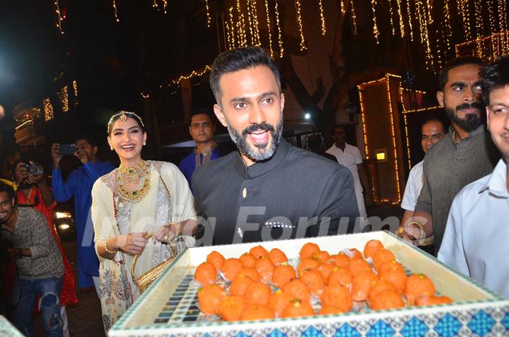 Sonam Kapoor and Anand Ahuja offer sweets to paparazzi