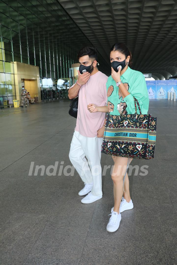 Anushka Sharma poses with Virat Kohli to the paparazzi at the Mumbai airport 