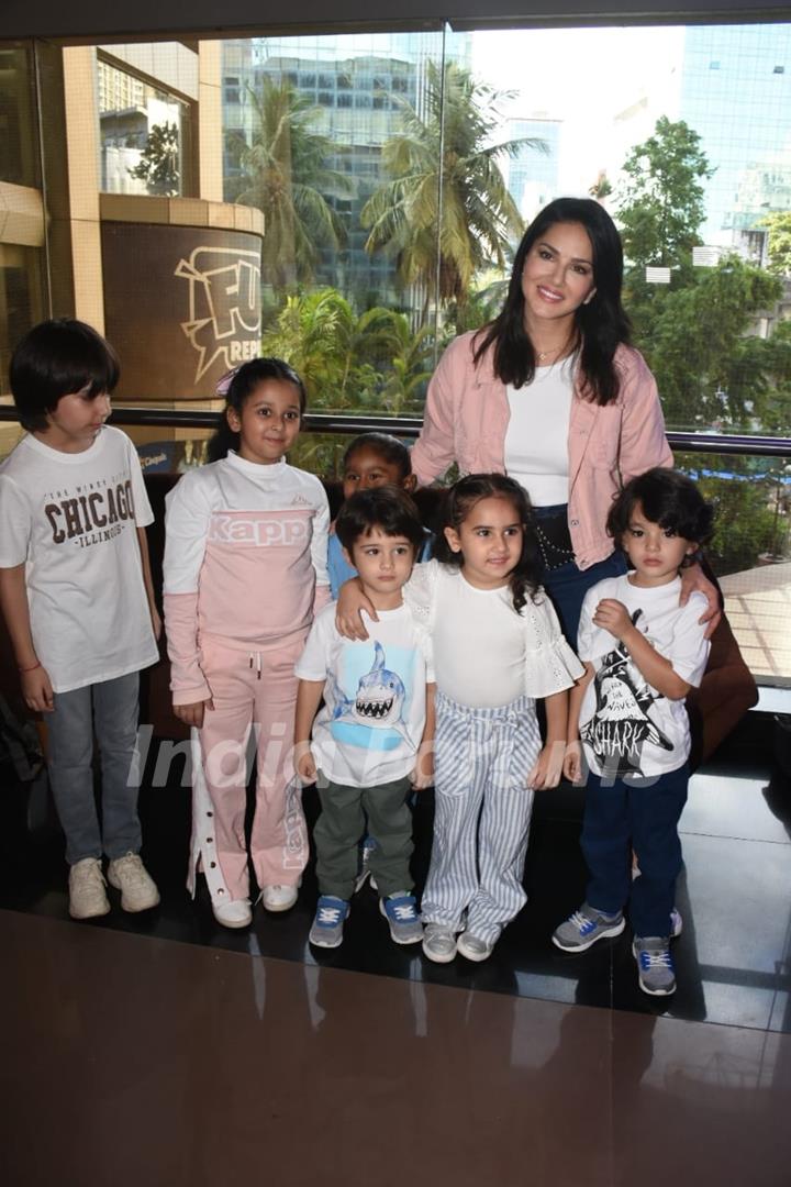 Sunny Leone poses with kids to paparazzi at the screening of Lightyear in Andheri