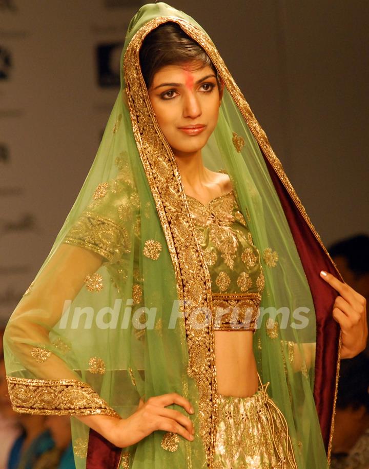 A model catwalks in an outfit design by a designer at the Kolkata Fashion Week in Kolkata on 10th Sep 2009