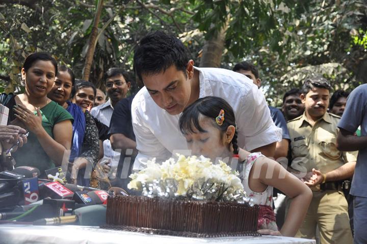 Aamir KHan blows his 45rd birthday candles with one of his child fans as he celebrated his birthday with media today at his home in Mumbai