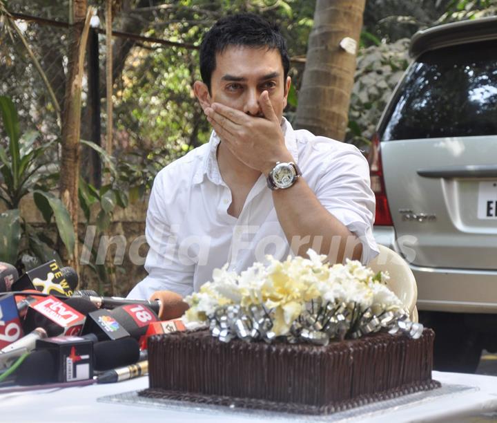 Aamir Khan gestures as he interacts with the media on his 45rd birthday at his home in Mumbai