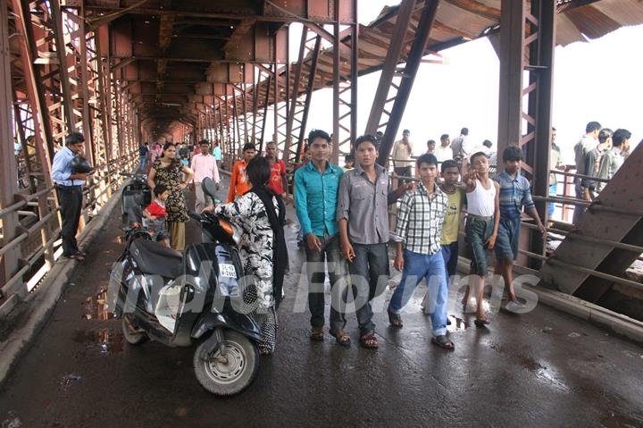 People watching overflowing Yamuna River at old bridge in  Delhi on Saturday