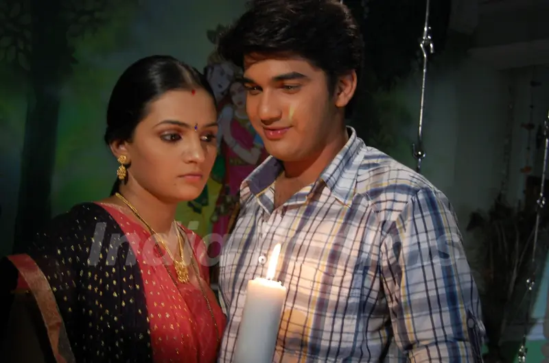 Mohan and Bhakti standing with a candle