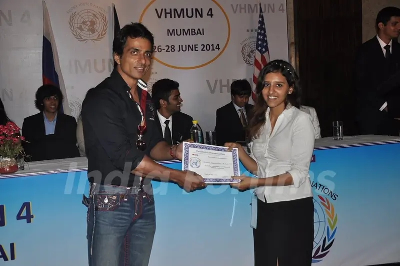 Sonu Sood giving certificate to student at MUNA event.