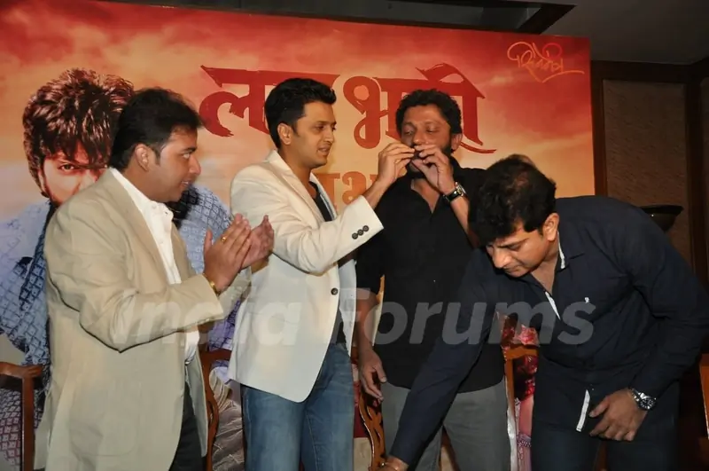 Riteish Deshmukh feeding cake to Nishikant Kamat at the Success Bash for Lai Bhari