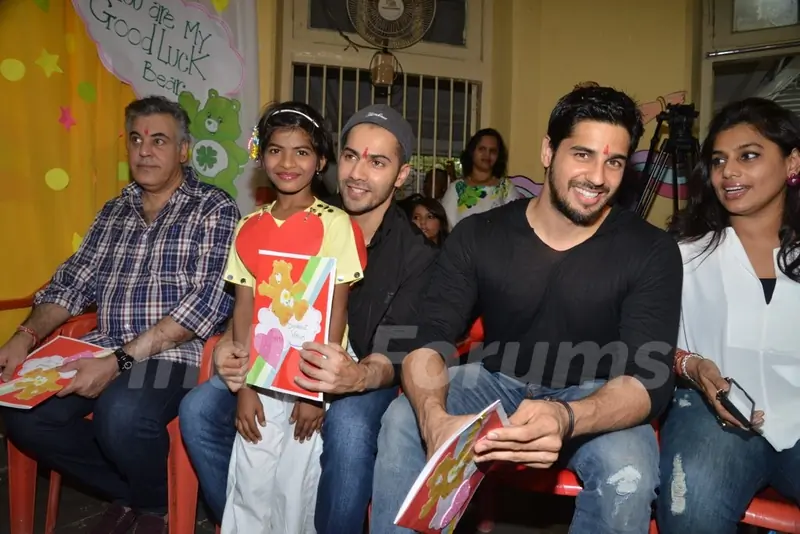 Varun Dhawan and Sidharth Malhotra pose with a kid at Ashray Ngo