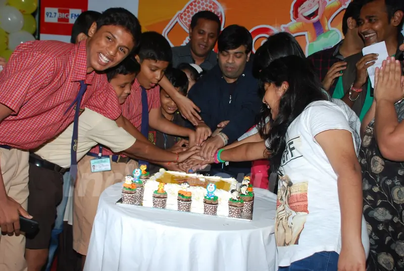 Kiku Sharda cuts the cake with children at Big FM Event