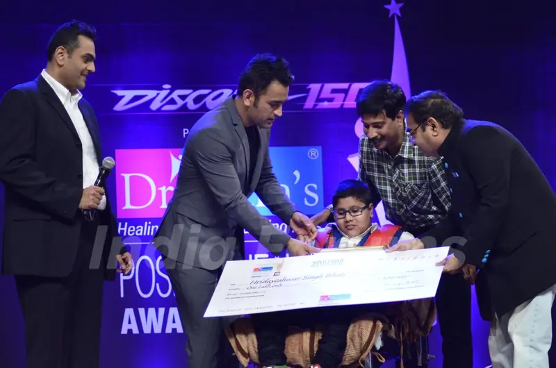 MS Dhoni presents an award to a special child at Positive Health Awards