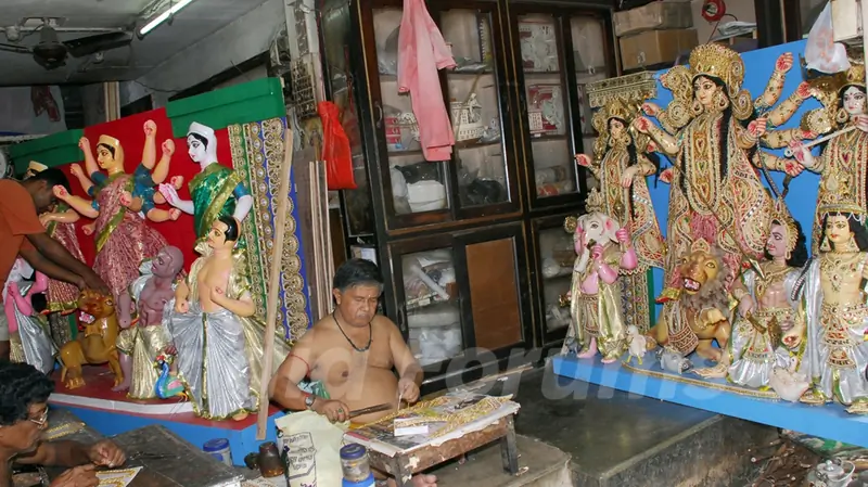 An Artist of Kumartuli finishing touch at a Durga idol made by Shola (Pith) for Overseas country (England left and Canada) in Kolkata on Wednesday 12th Aug 09