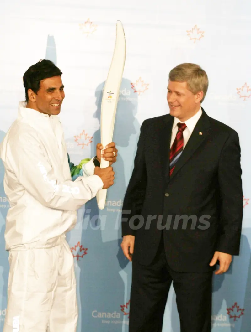 Canadian Prime Minister Stephen Harper and Bollywood Actor Akshay Kumar pose with a jacket, which will be worn by torchbearers for the 2010 Winter Olympics torch relay during an event at Trident in Mumbai on Monday, 16 November 2009