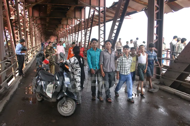 People watching overflowing Yamuna River at old bridge in  Delhi on Saturday